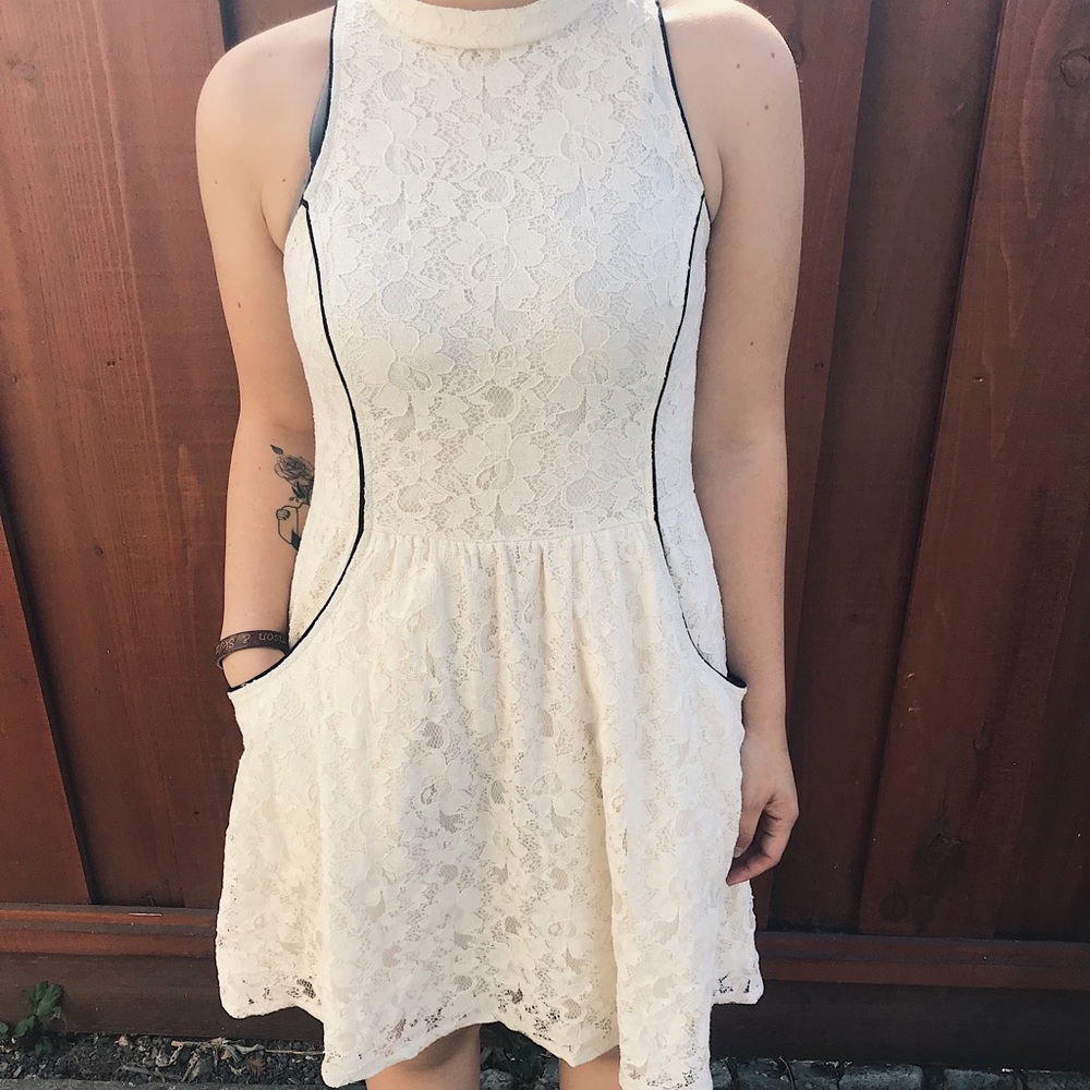 Off-white formal dress with floral inlaid designs.